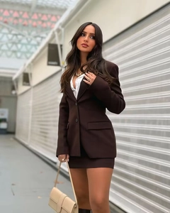 Detail of dark brown blazer and mini skirt suit with smooth woven fabric texture