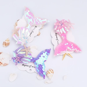 Close-up of pink, purple, and blue mermaid tail hair clips with sequins and starfish