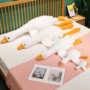 Set of five soft white goose plush pillows in various sizes on a cozy bed setup