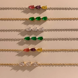 Detailed view of stainless steel bracelets with colorful drop-shaped zircon gemstones