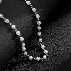 Detailed macro shot of vintage hip hop necklace with white pearls and crystal-encrusted beads