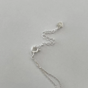 Macro detail of S925 sterling silver extender chain and spring clasp with heart charm