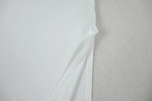 Detail view of the side slit sewing and plain weave fabric texture on a white dress