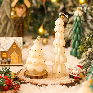 Miniature white Christmas tree candles with colorful dots on a wooden snowy base decoration