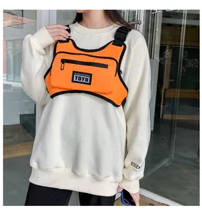 Detail der leuchtend orangefarbenen taktischen Brusttasche mit verstellbaren Riemen