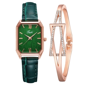 Close-up of vintage square watch with green leather strap and gold bracelet set