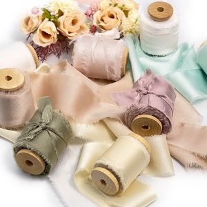 Frayed edge satin chiffon ribbons on wooden spools for elegant floral gift wrapping