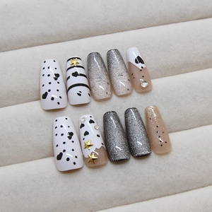 Cat-eye press-on nails set with silver stars, heart patterns, and rhinestone accents