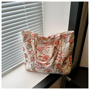 Detail of canvas tote bag with red and yellow floral pattern in natural window light