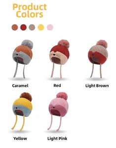 Detail view of colorful winter knit beanies with cute cat embroidery and pom-poms