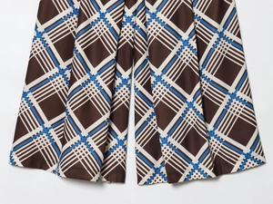 Vue détaillée du tissu sergé à carreaux marron et bleu avec des plis et un drapé élégants