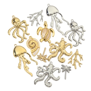 Macro detail of various gold and silver ocean charms like octopus, turtle and palm tree