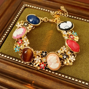 Macro detail of vintage floral portrait bracelet with colorful resin stones and gold plating