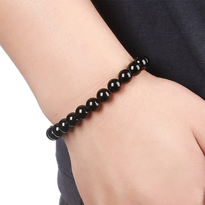 Close-up of polished black natural stone bead bracelet worn on a model's wrist