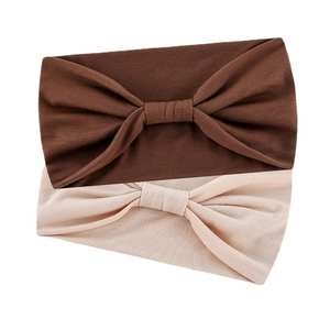 Brown and beige knotted headbands for yoga and sports made of soft fabric on white back