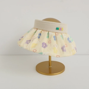 Detail of a floral empty-top sun hat for girls with colorful MISS 3D letters on a stand