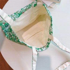 Detail view of floral cotton tote bag interior showing the inner pocket and lining