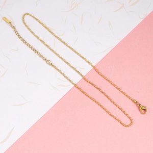 Detail view of golden stainless steel ball chain necklace with lobster clasp and extender