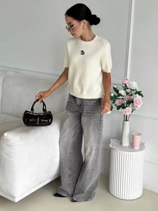 Top in maglia crema a maniche corte aderente con jeans grigi a gamba larga donna