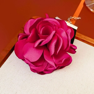 Close-up of a velvet rose choker featuring multilayered magenta petals and black ribbon strap
