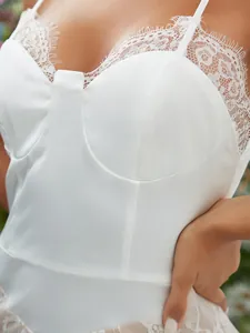 Détail du haut corset en satin blanc avec dentelle délicate et fines bretelles