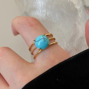 Close-up of triple-layered 18k gold-plated ring featuring a round turquoise stone