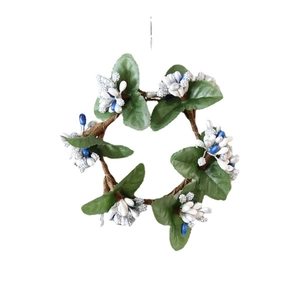 Artificial Christmas wreath with green leaves, white berries and blue accents on white base