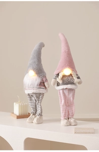 Close-up of glowing LED nose and knit texture on handmade pink and gray Christmas gnomes