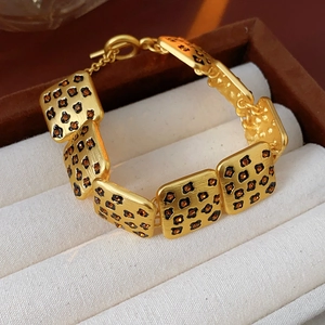 Detailed shot of golden square-link bracelet with leopard pattern and amber crystals