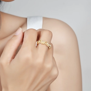 Minimalist gold flower ring with micro-set crystals worn on a finger for a chic look
