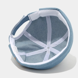Bonnet docker en denim bleu avec broderie de teckel montrant la doublure intérieure