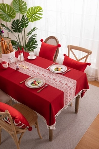 Detailed view of red Christmas reindeer jacquard tablecloth with creamy white tassels
