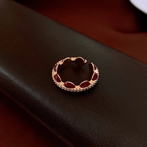 Macro shot of rose gold adjustable ring with red enamel inlay and vintage textured detail