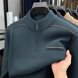 Detail of dark teal knit sweater featuring a quarter-zip collar and textured shoulder stripes