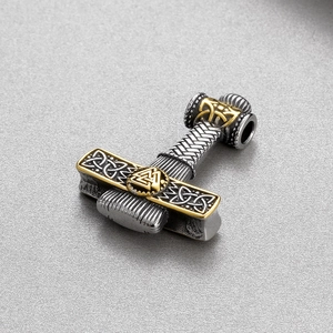 Macro detail of silver and gold Viking Mjolnir pendant with Valknut symbol and relief