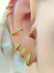 Macro shot of gold-plated huggie earrings set with sparkling micro-pave cubic zirconia