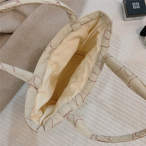 Top view of white quilted tote bag with red heart embroidery and spacious inner compartment