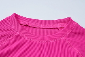 Détail du haut en maille côtelée violet rose avec col rond et finitions de couture soignées