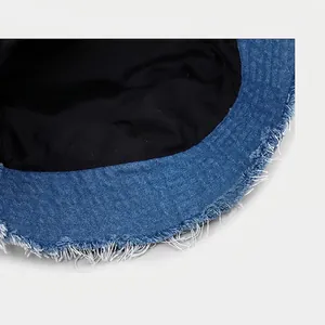 Distressed blue denim bucket hat featuring raw fringe edges and vintage patchwork styling