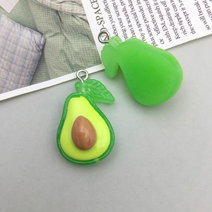 Macro view of realistic resin avocado charms with detailed pit and green leaf pendants