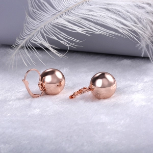 Elegant rose gold ball drop earrings on white faux fur background with a modern polished finish