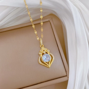 Detail of gold teardrop necklace with zircon pavé pendant on a leather jewelry box