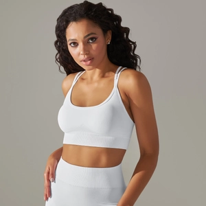 Detail of white seamless knitted sports bra showing elastic fabric and crossover back design