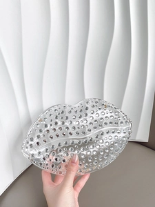 Sparkly crystal-encrusted lip-shaped evening clutch bag with diamonds in a hand-held view