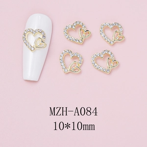 Detail of 10x10mm gold double heart nail charm with white rhinestones on pink background