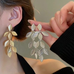 Detailed view of silver leaf tassel earrings showing delicate vein textures and dangles