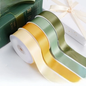 Macro detail of high-density satin ribbons in Morandi green tones for gift wrapping