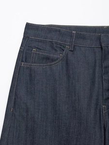 Dettaglio della vita dei jeans blu scuro con cerniera e cuciture a contrasto