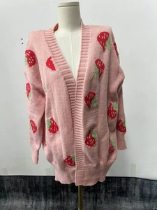 Detailed view of pink knitted cardigan with red strawberry jacquard and soft texture