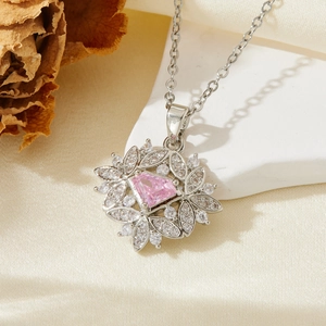 Détail macro du collier en argent avec pierre triangle rose et entourage en micro-pavage
